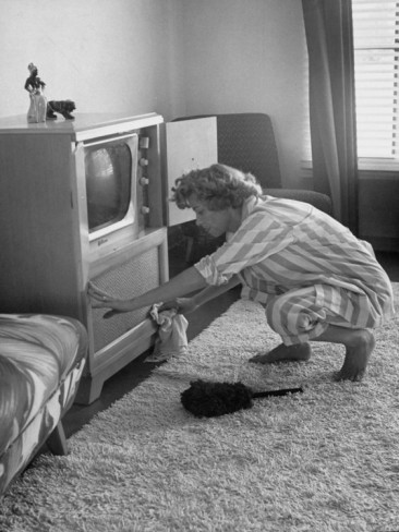 nina-leen-young-woman-attending-to-her-housework-by-dusting-off-her-television-set