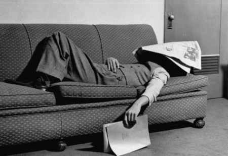 man with newspaper sleeping on the sofa