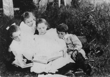 StateLibQld_2_125327_Group_of_children_sitting_on_the_grass_reading_books,_1900-1910