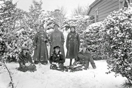 Outdoor portrait of six women in a snow covered backyard, ca. 1915-20