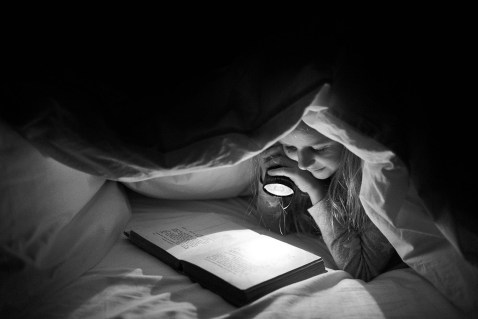 black-and-white-pic-of-girl-reading-in-bed-with-a-flashlight-by-Liza-Hall